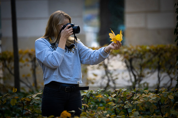 Fiatal lány leveleket fotóz hagyományos fényképezőgéppel