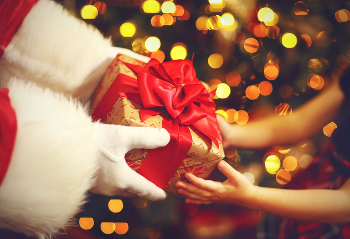 hands of Santa Claus give a child a Christmas gift - Startlap