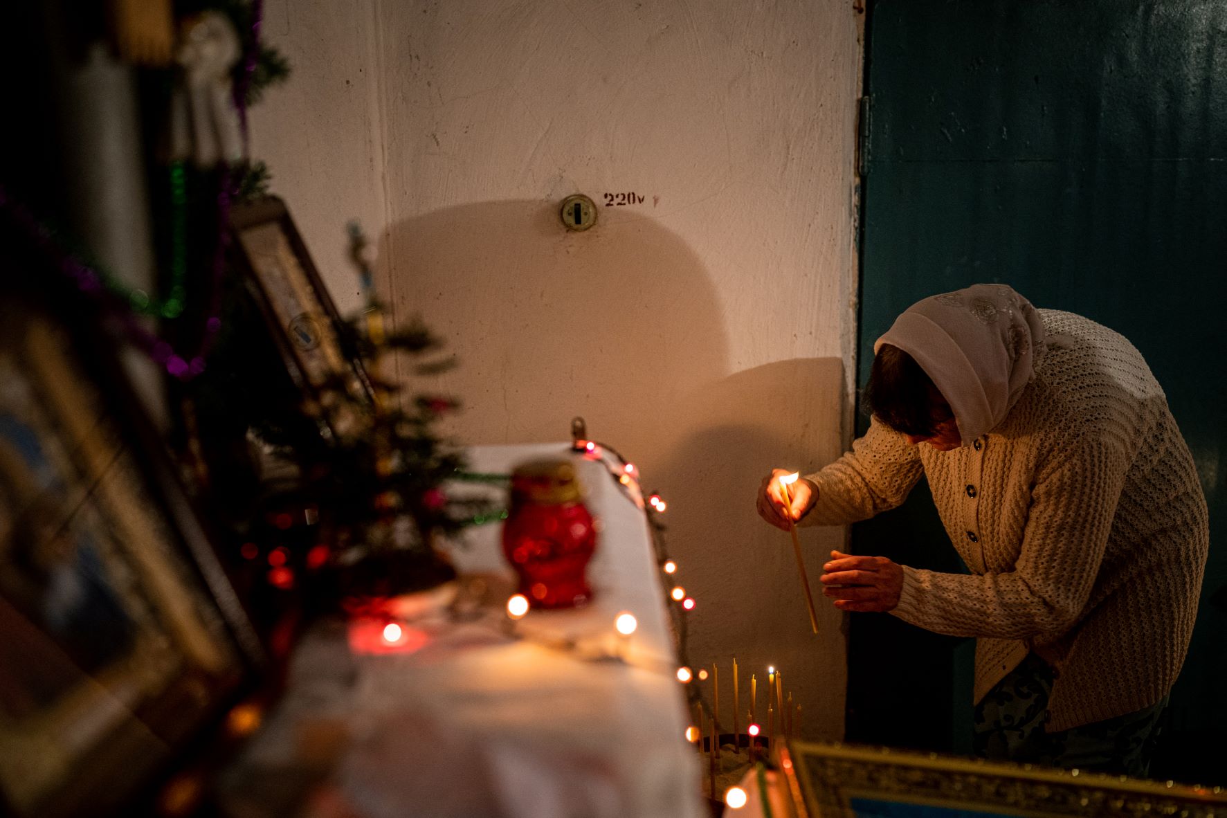 Egy hívő gyertyát gyújt egy ortodox karácsonyi mise alatt a kelet-ukrajnai Chasiv Yar egyik pincéjében.