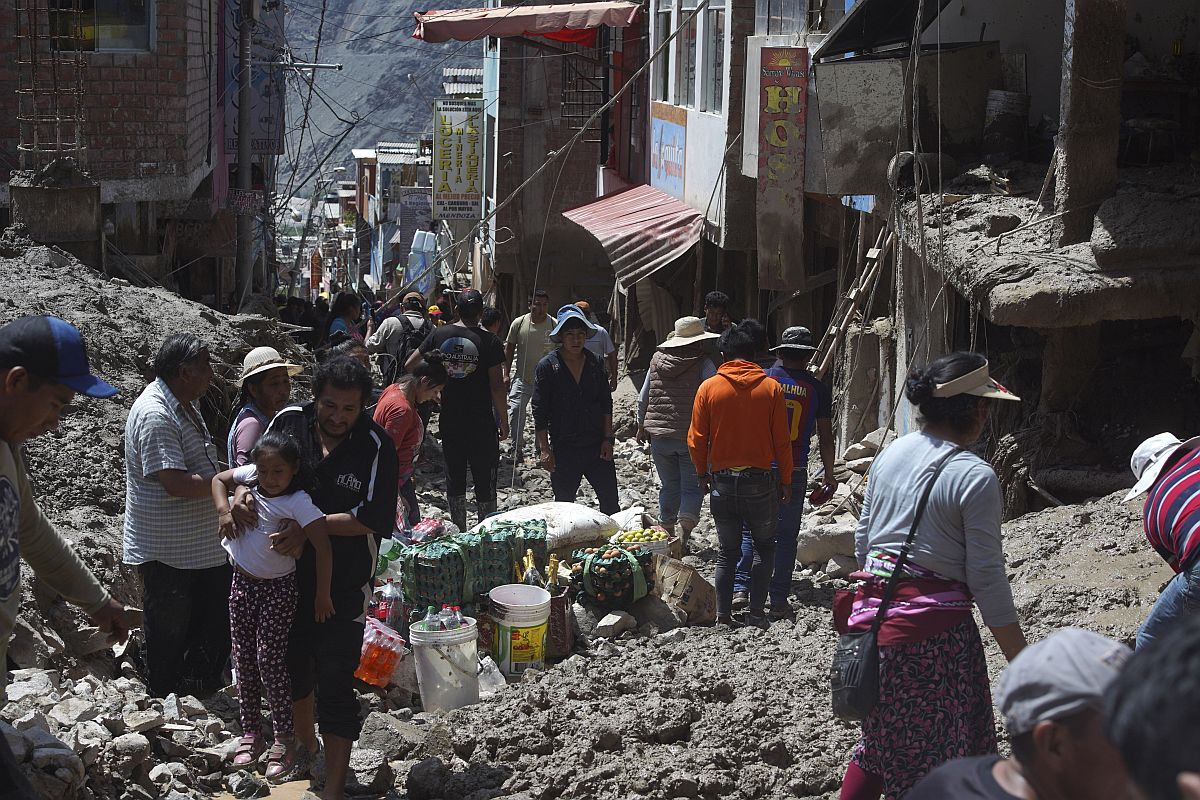 A még használható holmikat mentik a földcsuszamlás következtében megsemmisült otthonukból helyi lakosok a perui Camana egyik törmelékkel borított utcáján 2023. február 7-én.