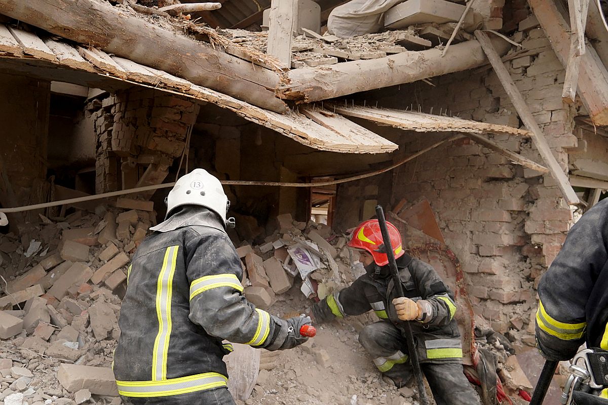 A mentőalakulat tagja dologoznak az orosz rakétatámadásban összedőlt lakóház romjainál Lvivben, 2023.03.09-én