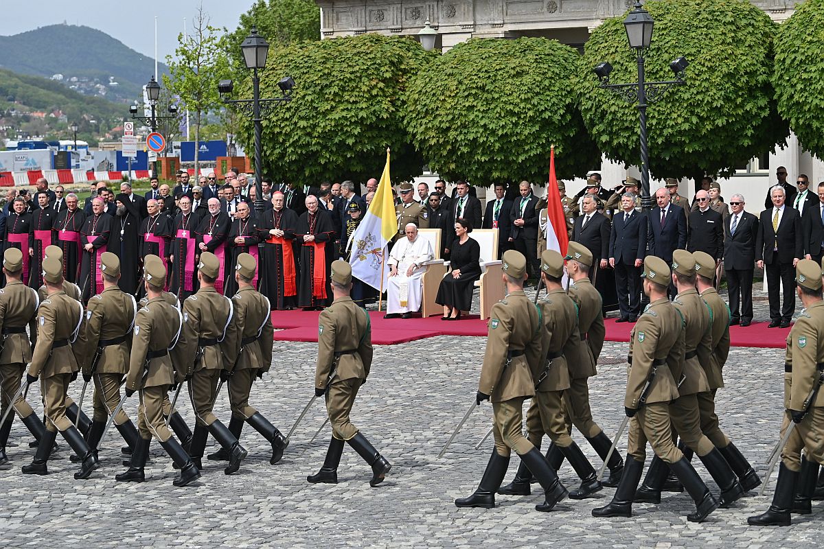 Novák Katalin köztársasági elnök katonai tiszteletadás mellett fogadja Ferenc pápát.