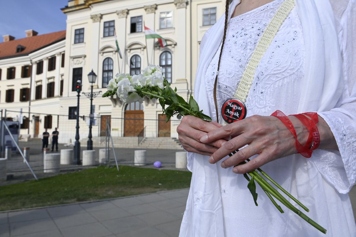 Részvevő virággal a kezében a rendhagyó anyák napi tüntetésen a Karmelita kolostor előtt 2023. május 7-én. 