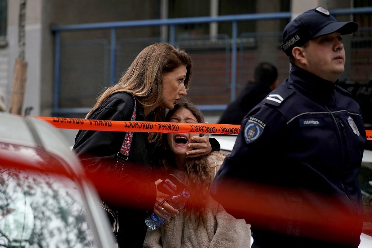 Szülő és gyermeke a belgrádi iskolai lövöldözés helyszínén.