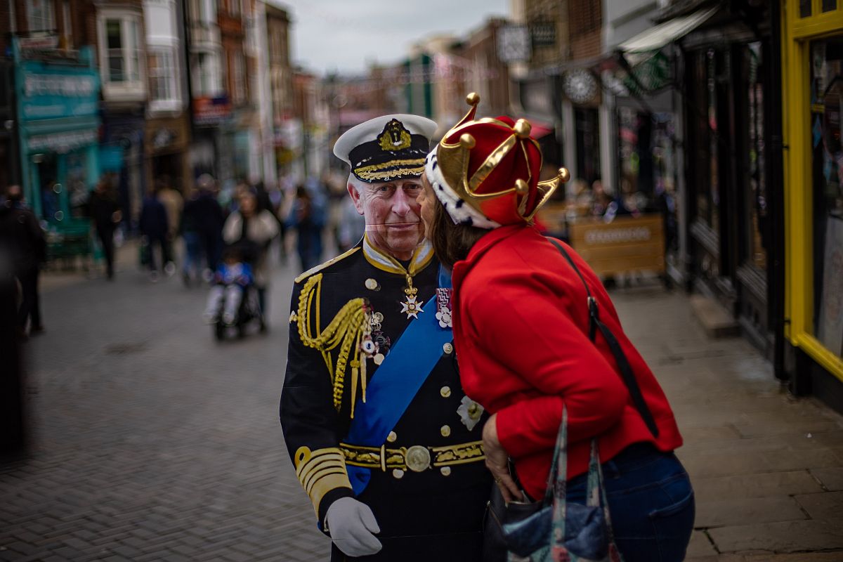 III. Károly brit királyt ábrázoló kartonfigurát csókol meg egy nő az angliai Windsorban tartott utcabálon.