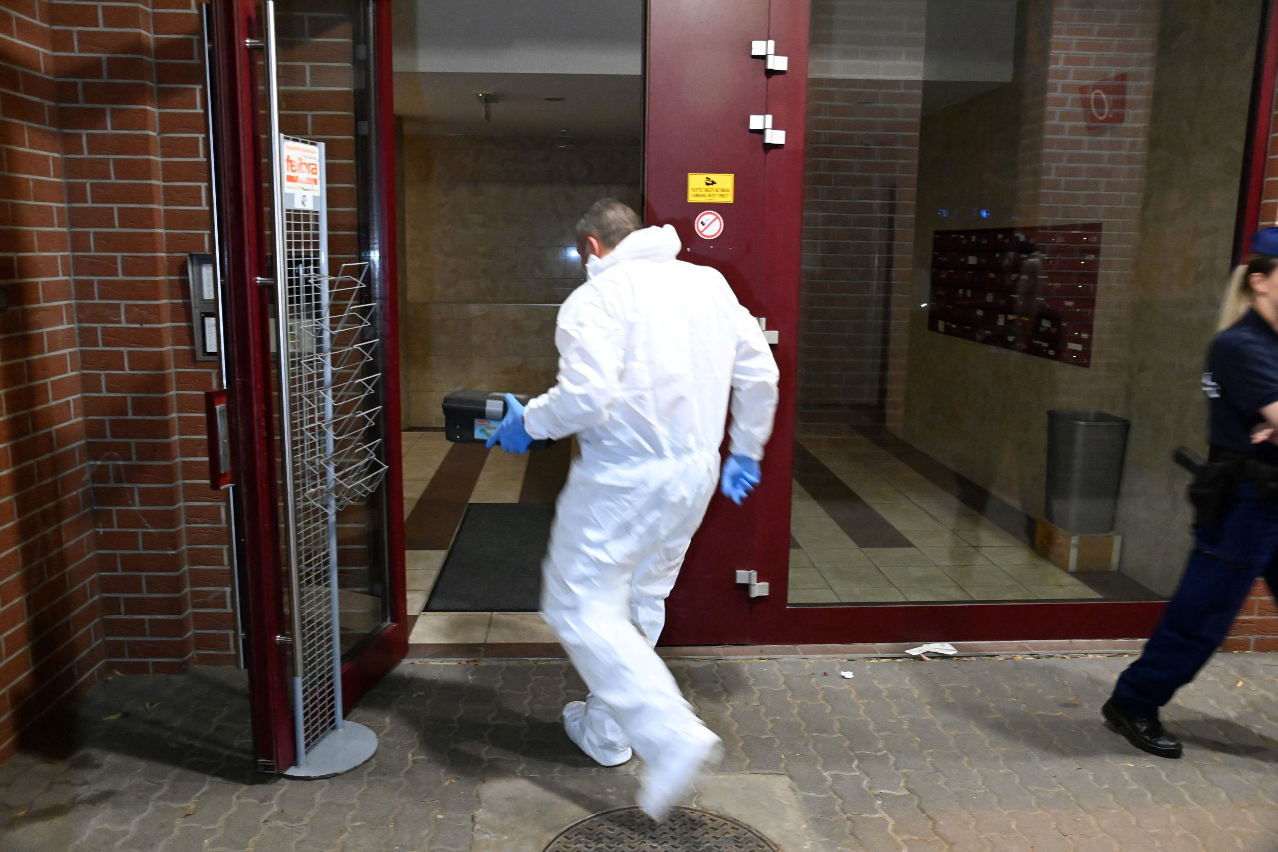 Bűnügyi technikus helyszínel 2023. július 14-re virradóan egy XIII. kerületi társasház előtt, miután az egyik lakásban holtan találtak egy 27 éves nőt. A gyilkosság feltételezett elkövetője után hajtóvadászatot indítottak a rendőrök.