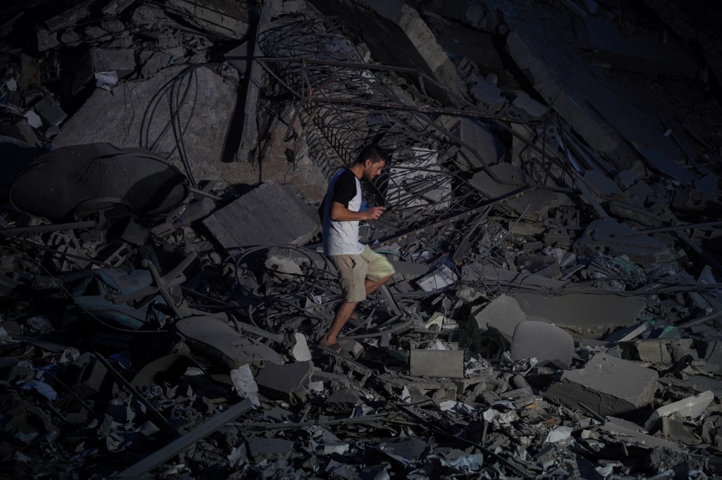 Egy férfi sétál egy izraeli légicsapás által eltalált épület romjai között Gáza városában.
