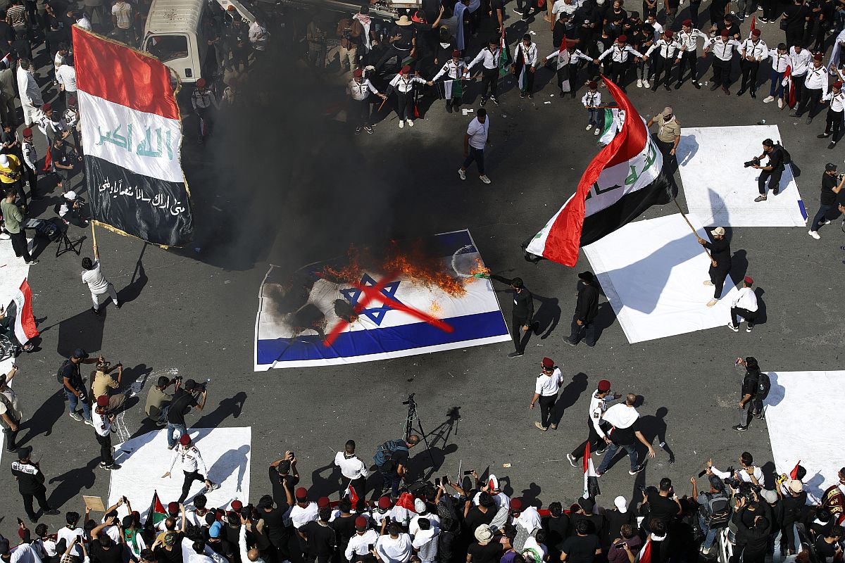 Izraeli zászlót égetnek a palesztinpárti tüntetők Bagdadban, 2023. október 13-án.