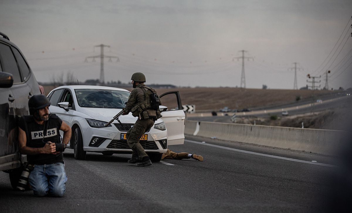 Egy fotós menedékben, a háttérben egy izraeli katona bevetésen a palesztin Hamász ellen.