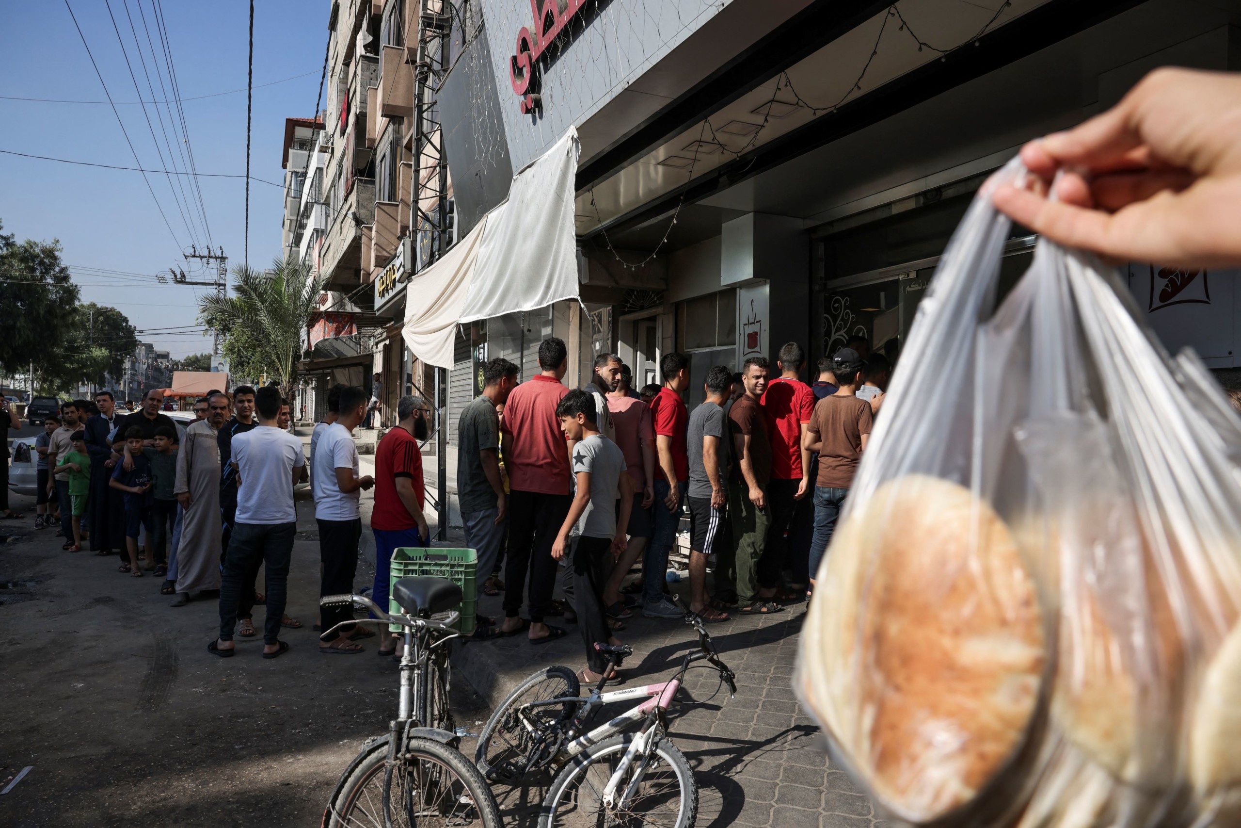 Az emberek sorban állnak egy pékség előtt Gázában 2023. október 7-én, a konfliktus eszkalálódásától tartva.