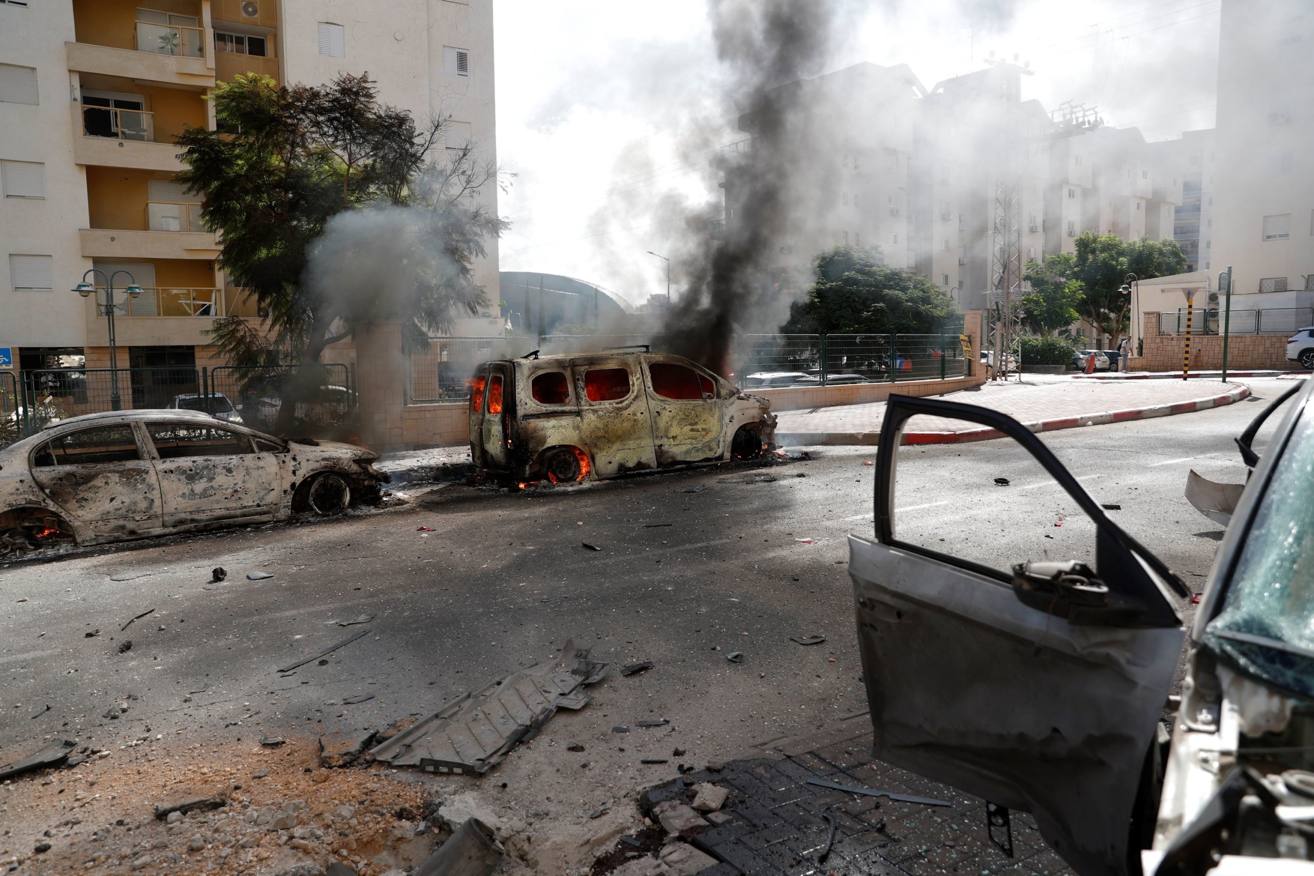 Palesztin rakétatámadásban kigyulladt járművek lángolnak az izraeli Askelónban 2023. október 7-én.