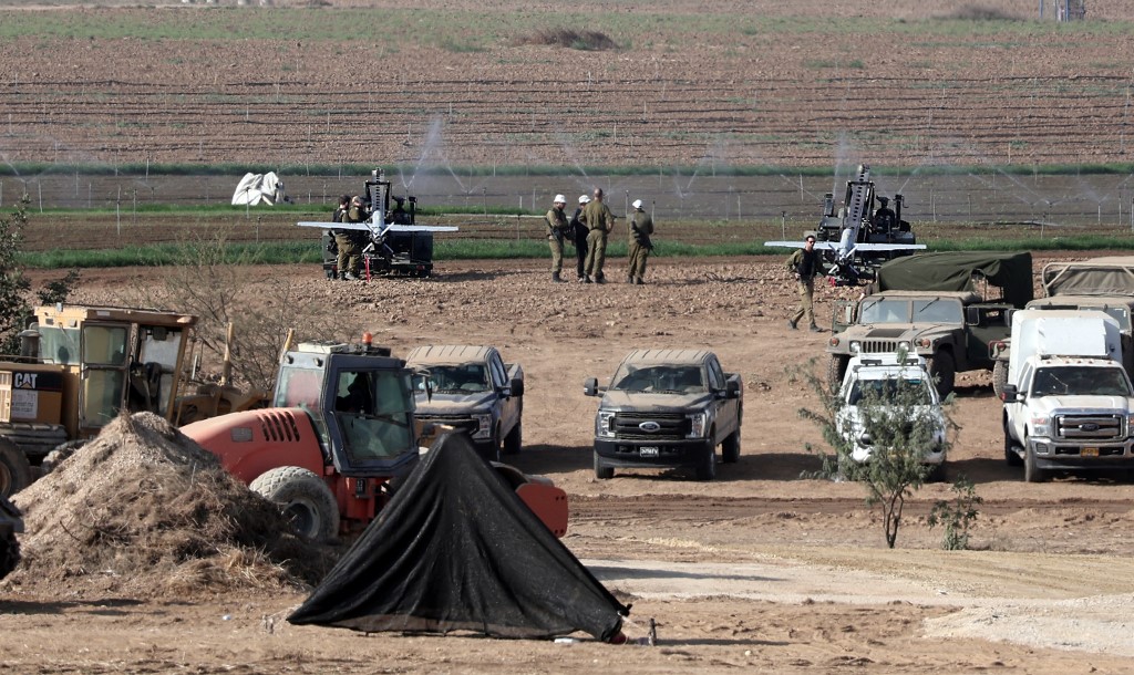 Izraeli katonák a palesztin Gázai övezet enklávéja közelében állomásozó fegyveres drónokat készítik elő a dél-izraeli Szderót város közelében lévő mezőn