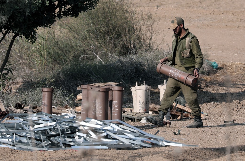Egy izraeli katona viszi a Gázai övezet palesztin enklávéja felé kilőtt izraeli tüzérségi aknavető csövét a dél-izraeli Szderót város közelében lévő mezőn