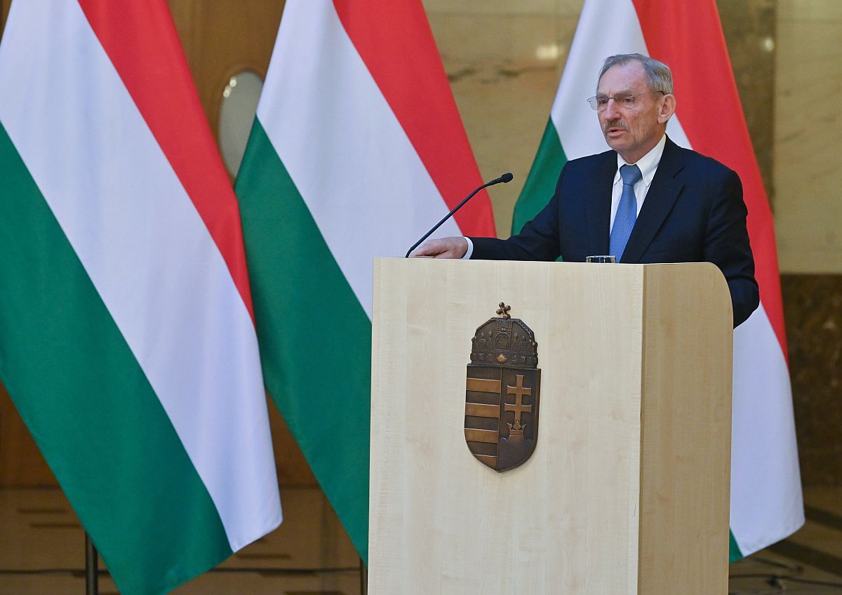 Pintér Sándor belügyminiszter beszél a pulpitusról magyar zászlók előtt.