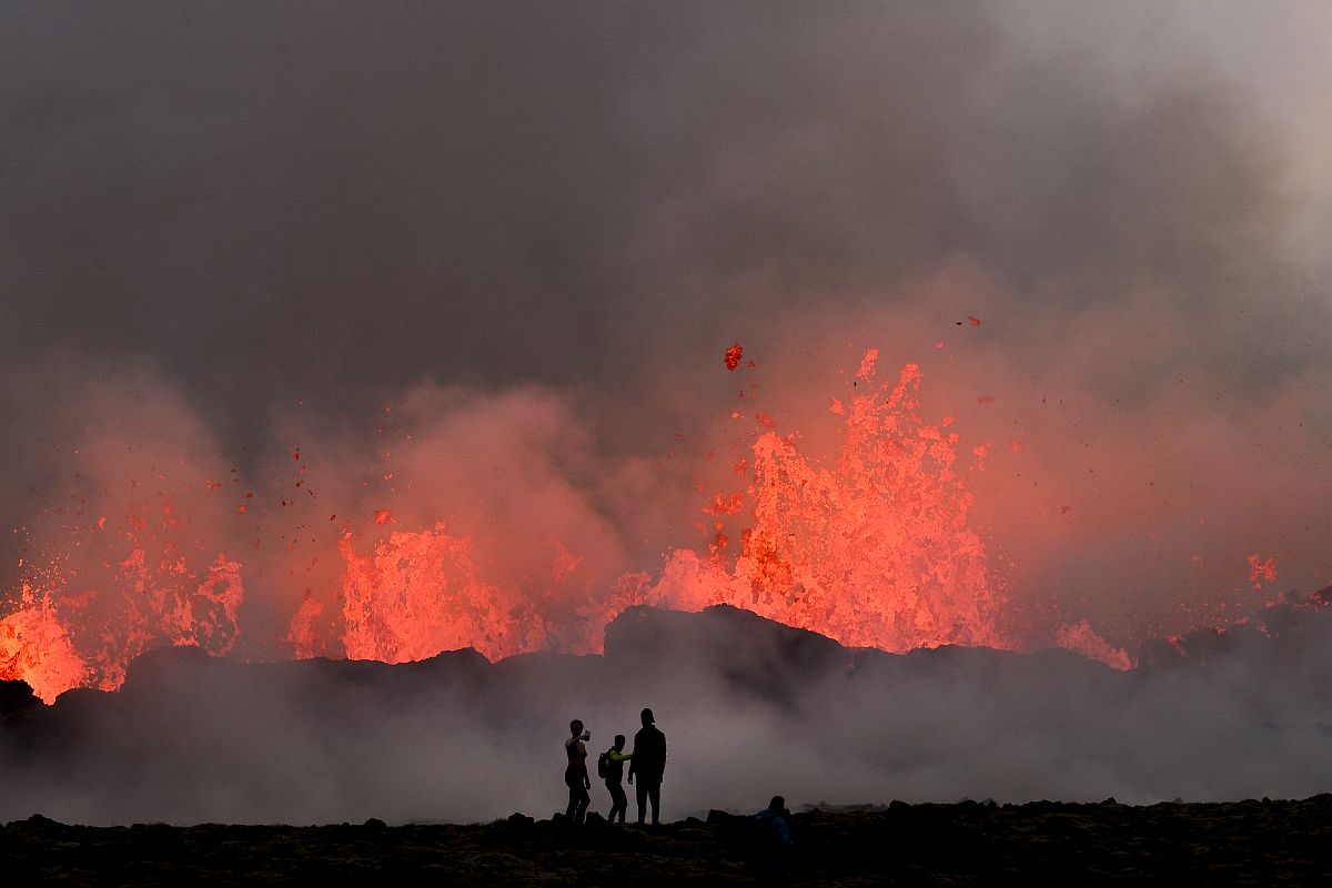 Vulkánkitörést néző emberek Izlandon.