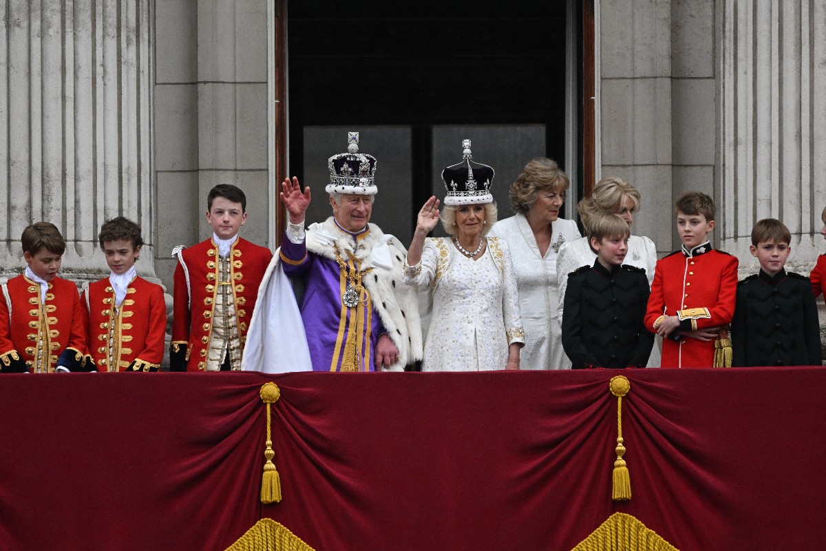 III. Károly brit király és a felesége, Kamilla királyné a londoni Buckingham-palota erkélyéről integet az uralkodó koronázási ünnepsége után, 2023. május 6-án. Balról a király unokája, az egyik apród szerepét betöltő György herceg, a trónörökös elsőszülött fia.