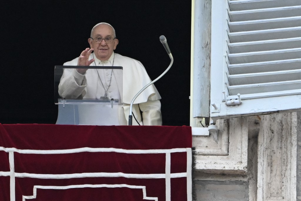 Ferenc pápa integet a Szent Péter térre néző apostoli palota ablakából az Angelus ima közben a Vatikánban 2023. december 24-én. Tiziana FABI / AFP