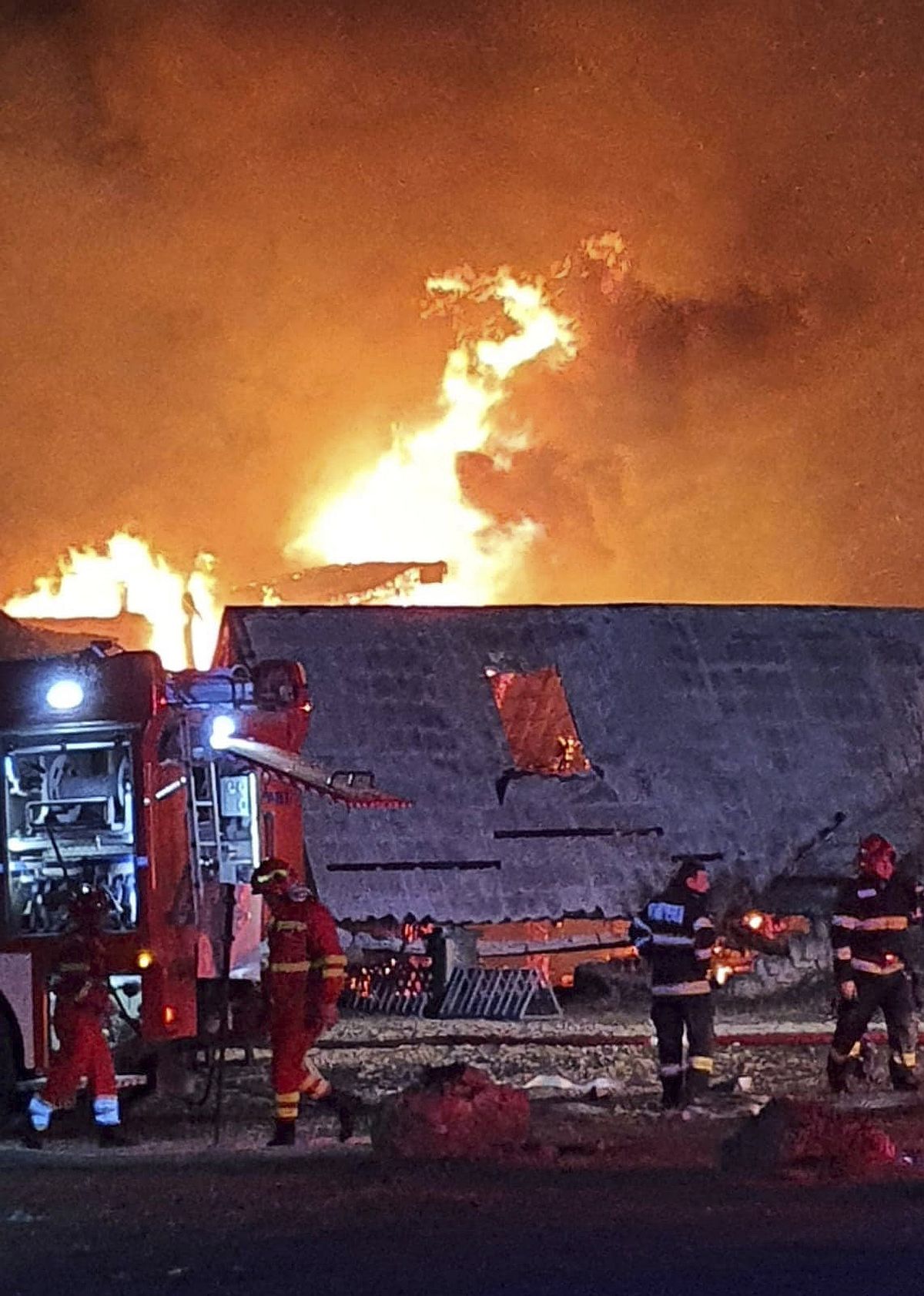 A Prahova megyei katasztrófavédelmi felügyelőség (ISU Prahova) által köreadott képen tűzoltók küzdenek a lángokkal egy kigyulladt panziónál a dél-romániai Tohani településen 2023. december 26-án.