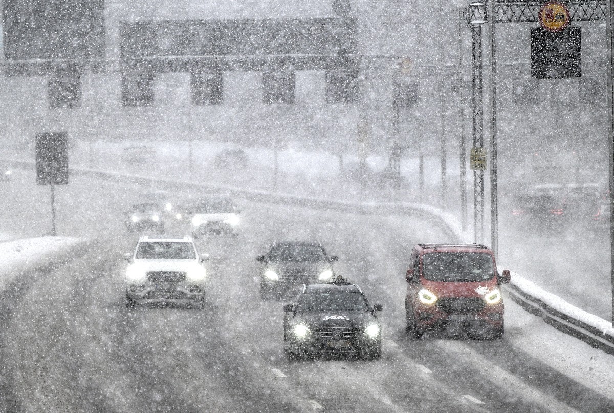 Járművek haladnak a szakadó hóesésben Stockholmban