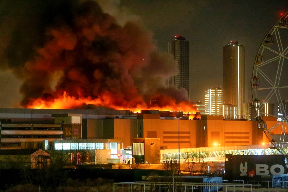 Füst száll fel a lángoló Crocus City Hall nevű hangversenyteremből, amelyben katonai terepruhát viselő fegyveresek tüzet nyitottak Krasznogorszkban 2024. március 22-én. Az épületben tűz ütött ki, a támadásnak halottjai és sebesültjei is vannak.