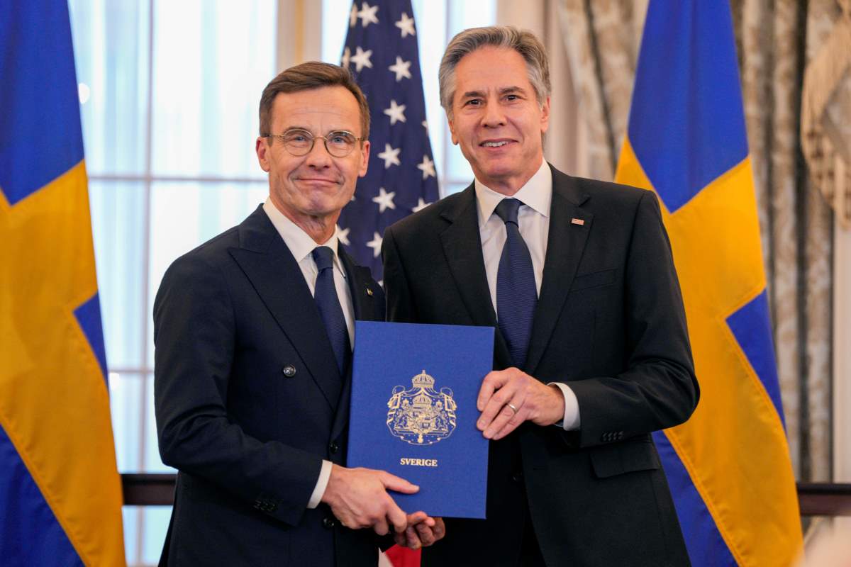 Ulf Kristersson svéd miniszterelnök (b) letétbe helyezi országa NATO-csatlakozásának ratifikációs okmányait Antony Blinken amerikai külügyminiszter jelenlétében a washingtoni külügyminisztérium Benjamin Franklin termében