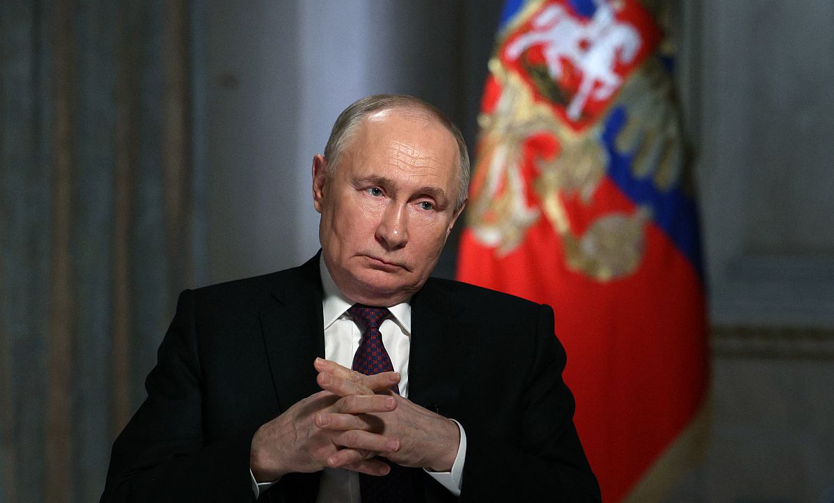 Vlagyimir Putyin interjút ad, a háttérben egy orosz zászló.