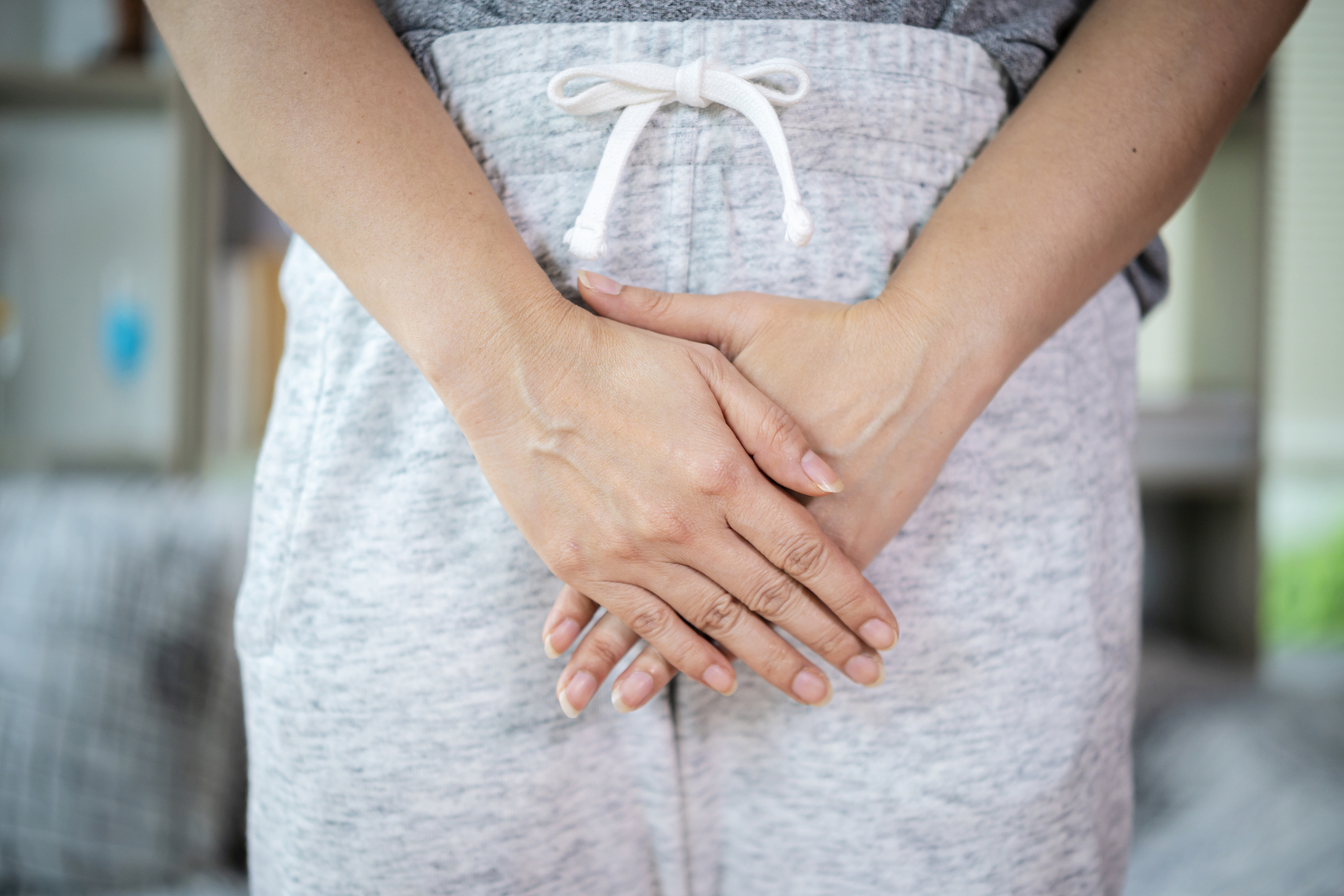 Hasát fájlaló szürke nadrágos nő