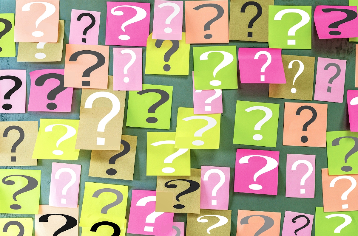 Close-up image of a question mark symbol on Paper note on a wooden wall - Startlap