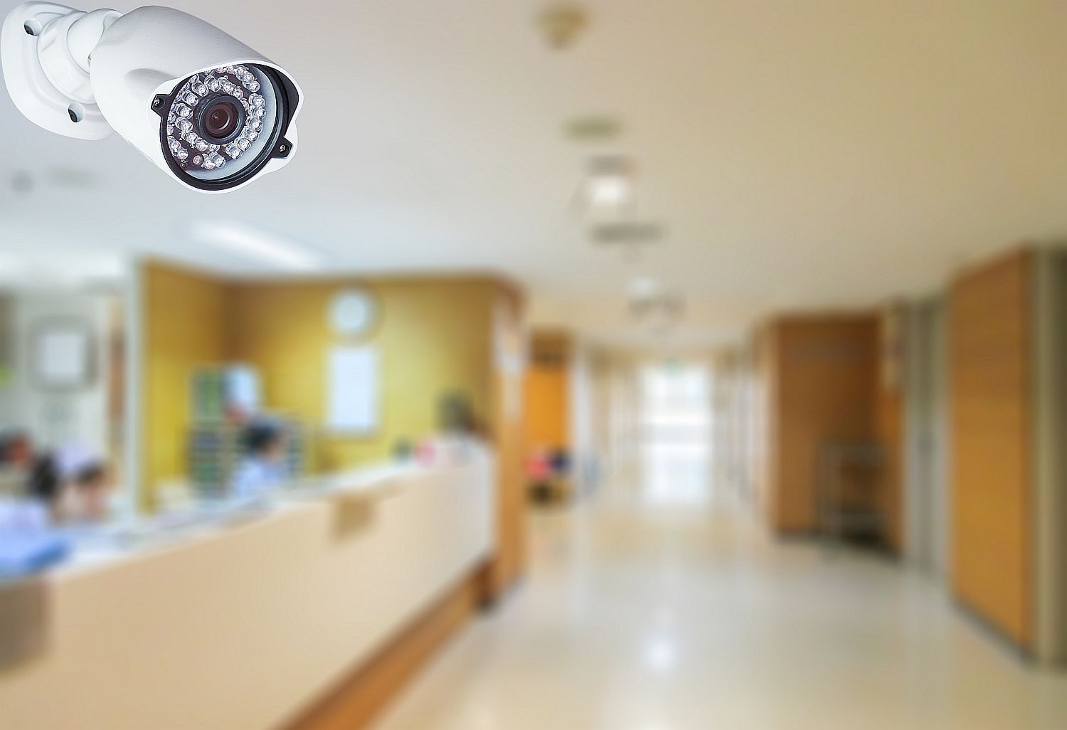 CCTV camera system - Startlap Egy falra szerelt kamera egy elmosódot intézményi térben.