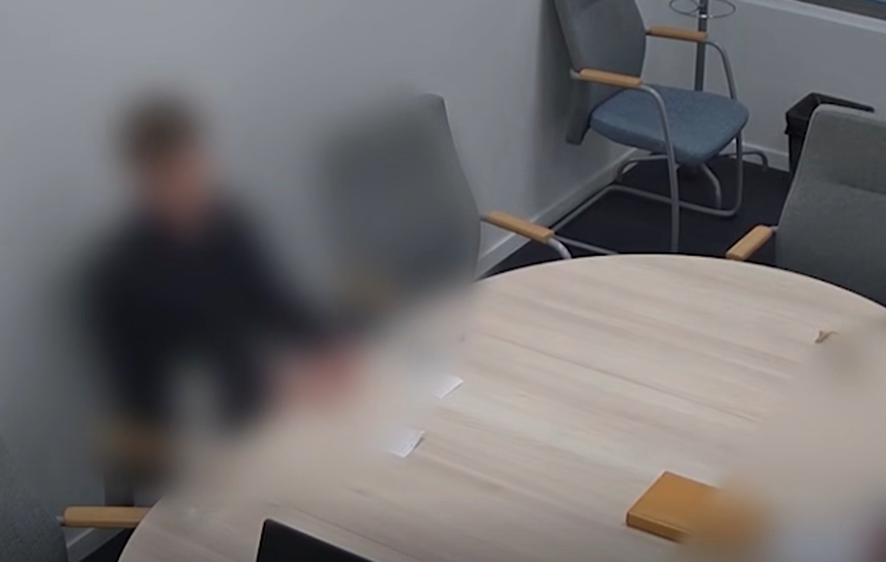 Egy férfi ül egy szobában egy asztal előtt