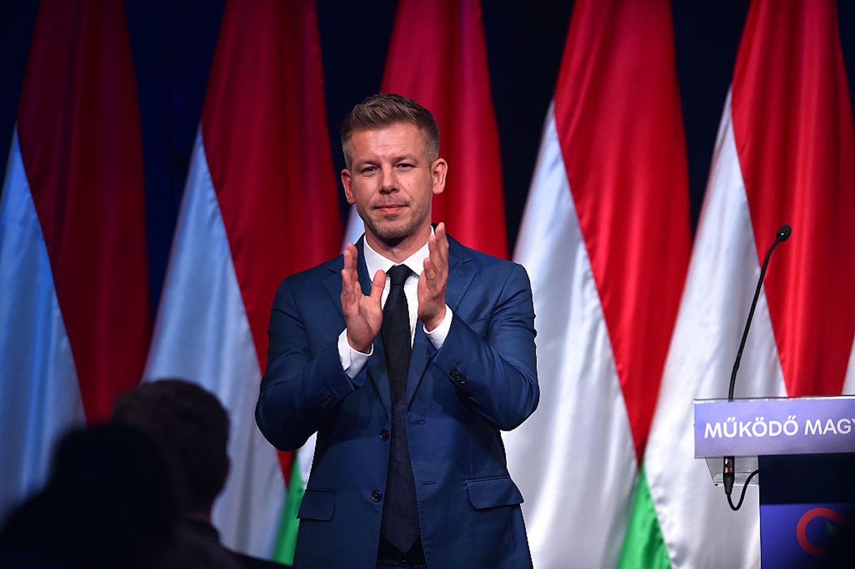 Magyar Péter a Tisza Párt vezetője nemzeti színű zászlók előtt tapsol