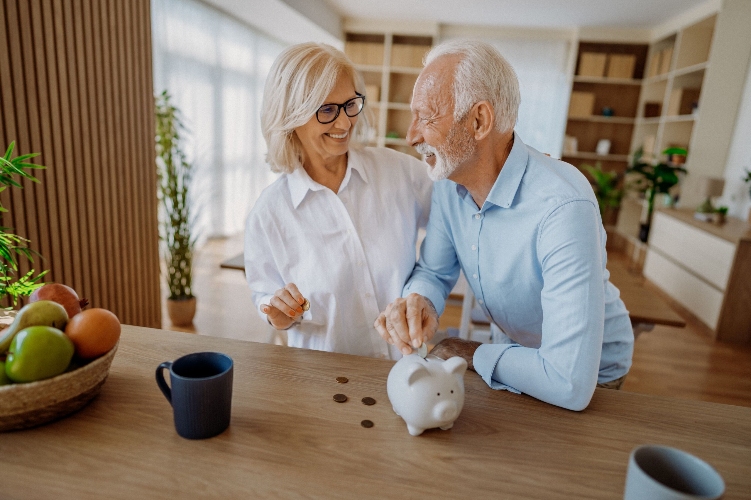 nyugdij2 - Startlap Nyugdíjas pár mosolyog egymásra, előttük egy malacpersellyel.