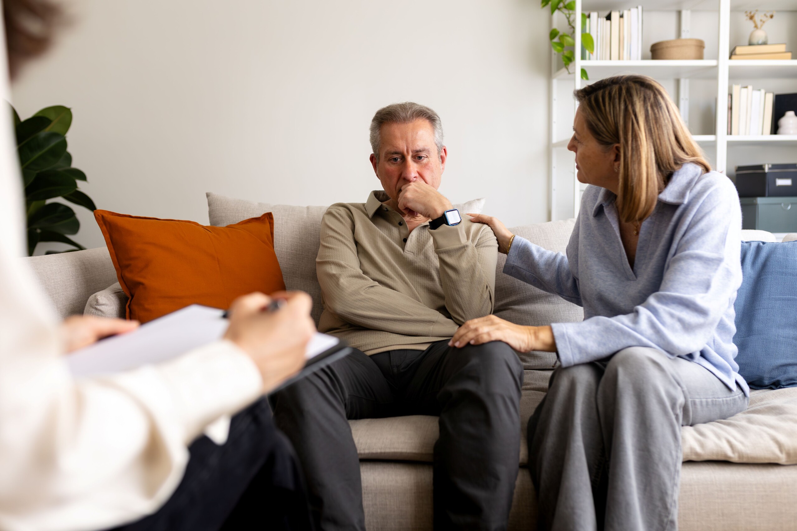 Egy nő támogat egy férfit egy pszichológus ülésén.