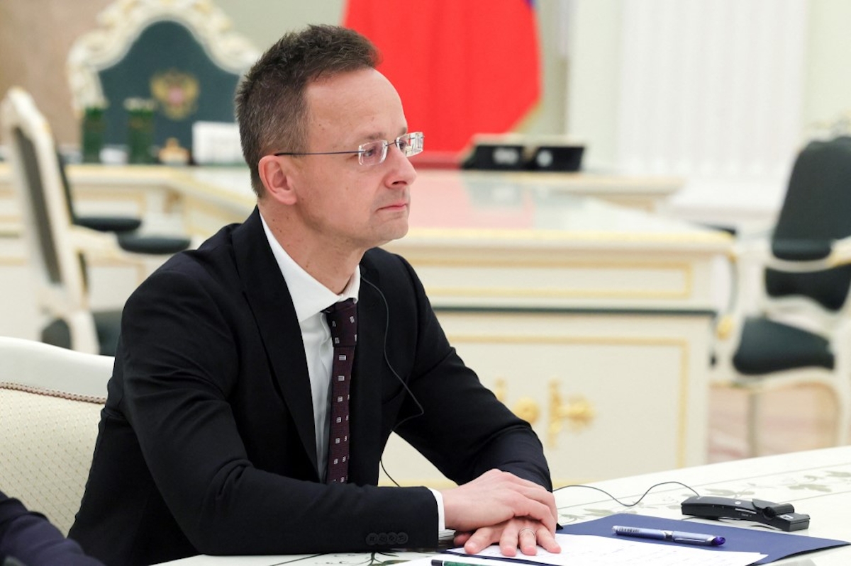 Szijjártó Péter ül egy asztalnál egy nemzetközi találkozó