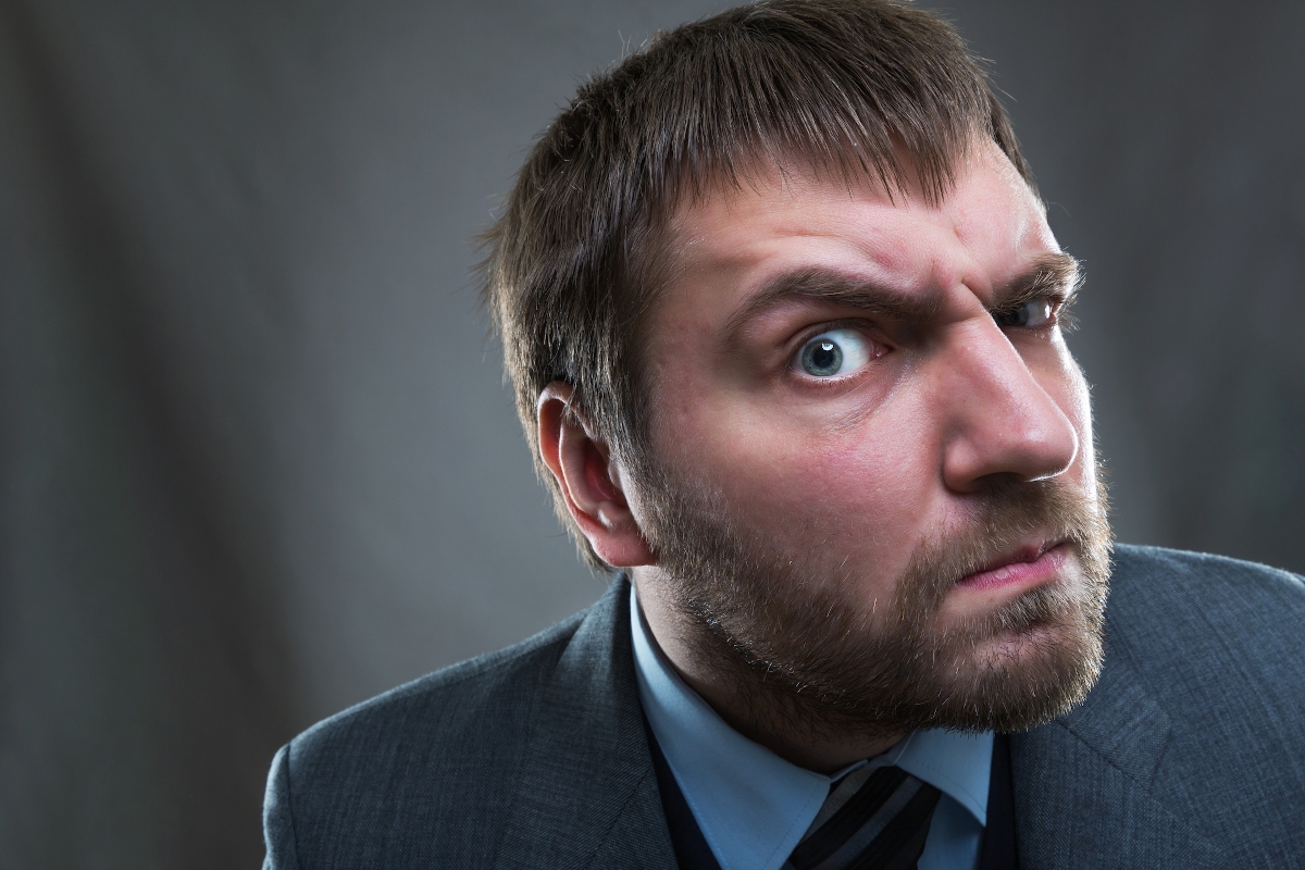 Szakállas férfi kifülledt szemmel furcsán néz