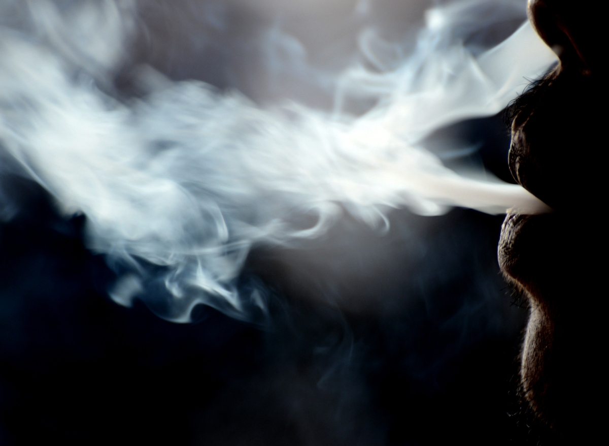 Egy férfi szájából és orrából ömlik a füst