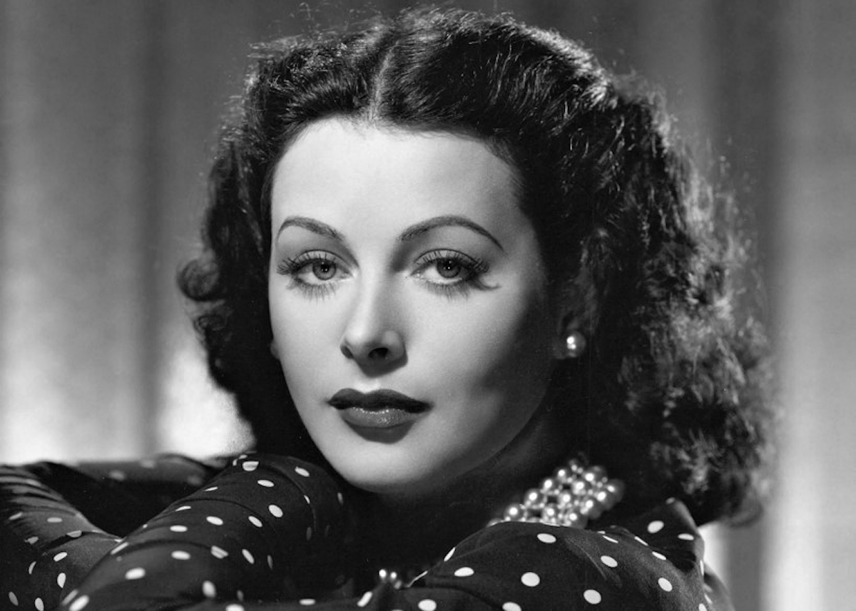 Hedy Lamarr színésznő egy estélyi ruhában néz bele a kamerába, fülében egy gyöngy fülbevaló látható