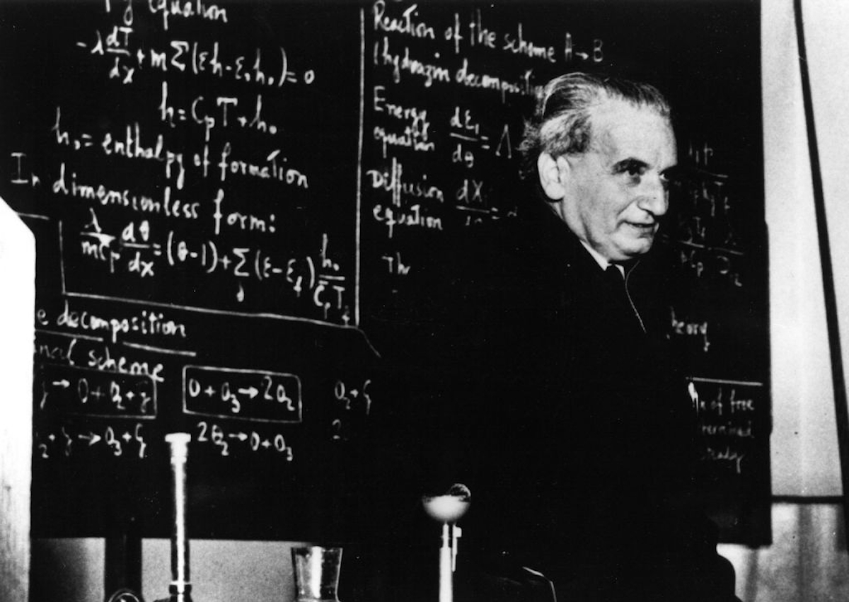 Kármán Tódor világhírű tudós áll egy katedrán, a háta mögött a táblán egy előadás vázlata látható