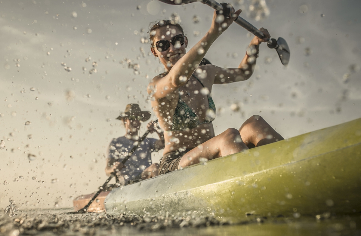 Egy fiatal evez a csónakban egy folyón