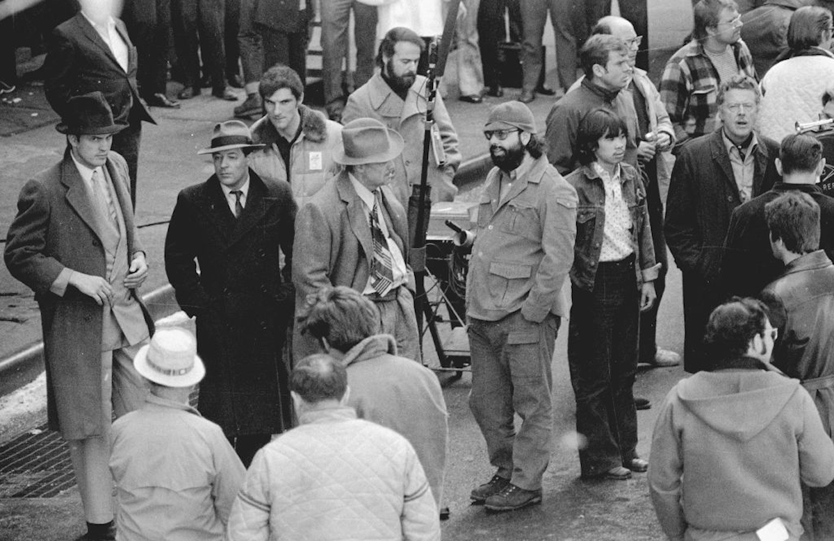 A Keresztapa című film forgatása a harmincas évek korhű ruháiba bújt színészekkel, középen Marlon Brando és a rendező, Francis Ford Coppola