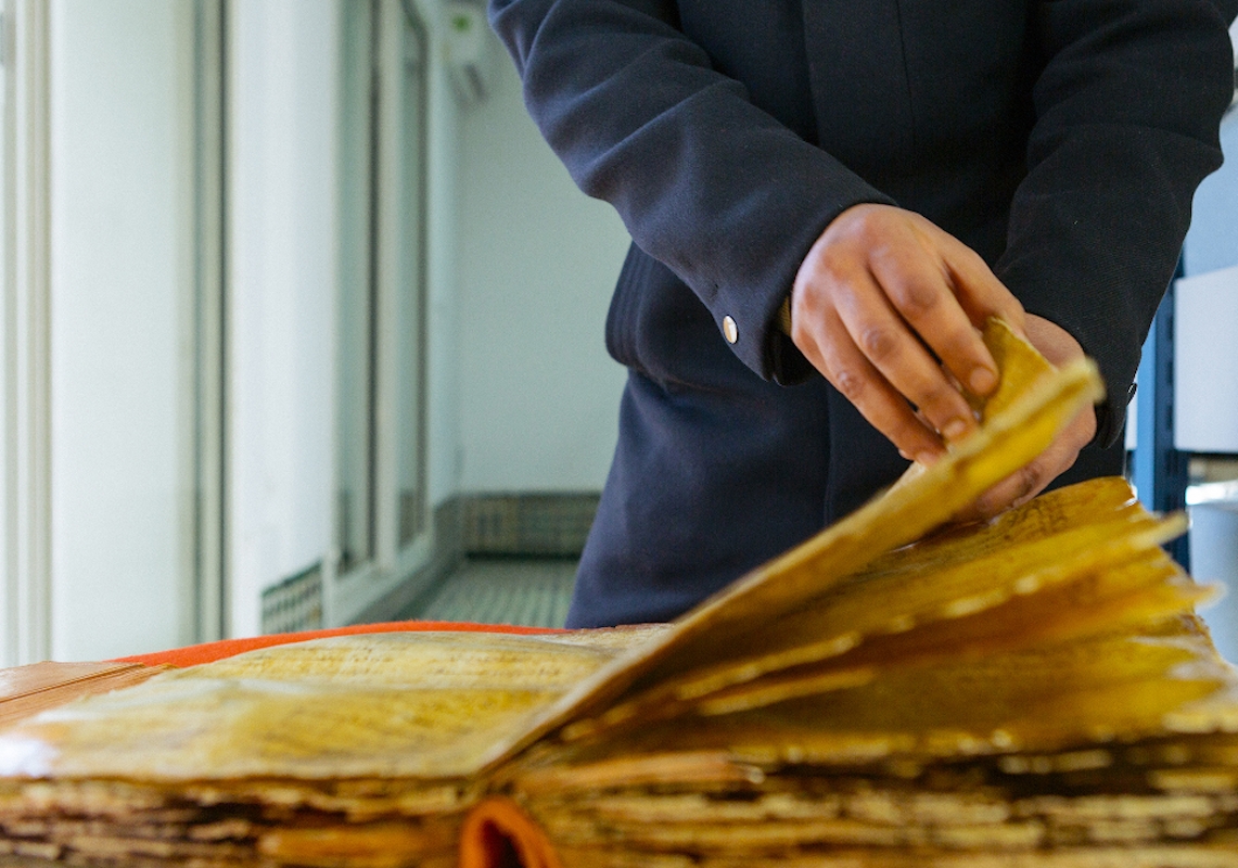 Egy öltönyös férfi kódexet lapoz