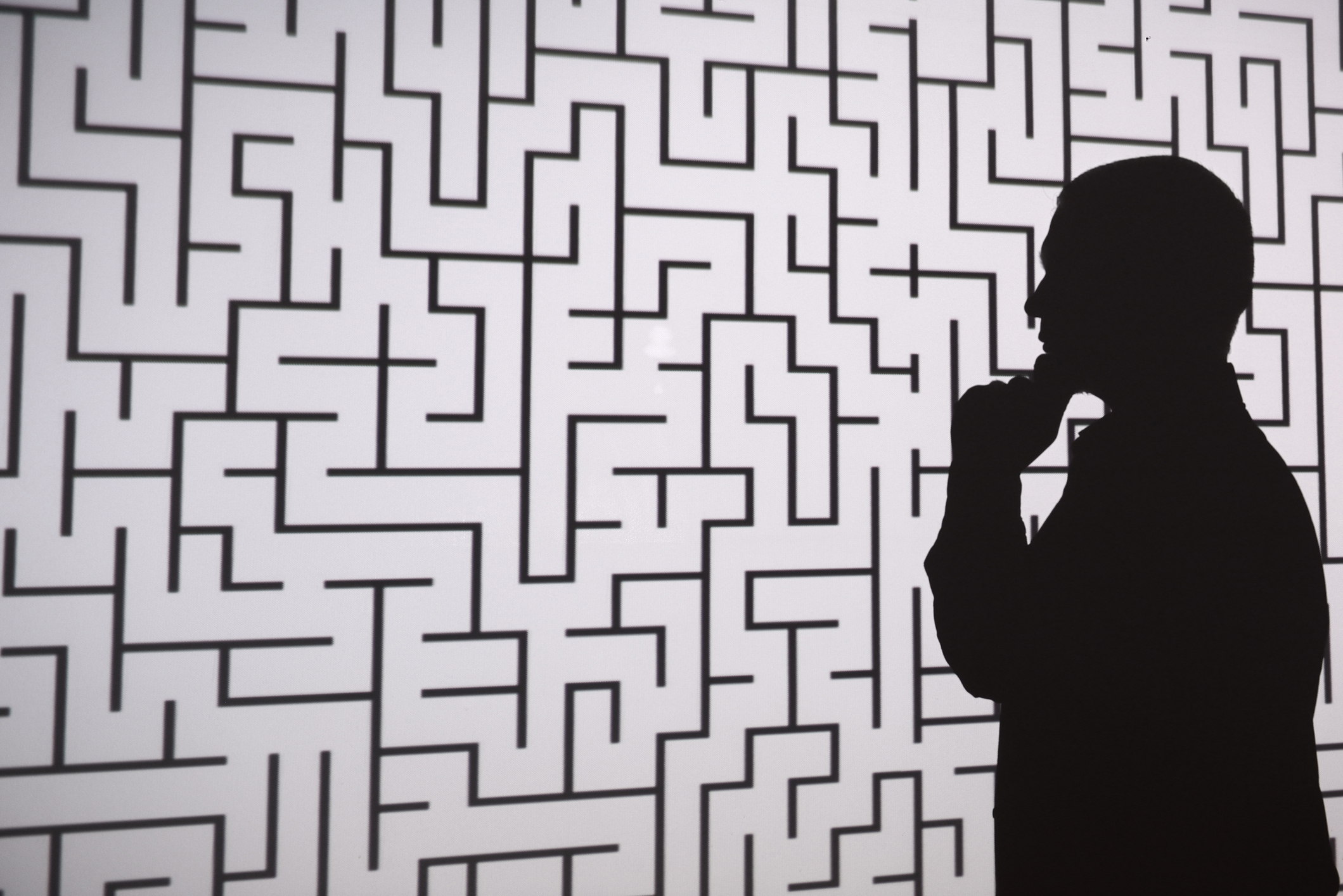 Egy férfi áll a labirintus előtt, és a kiutat keresi