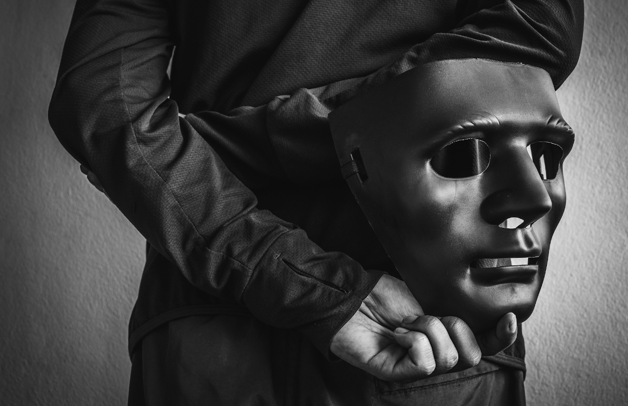 Egy feketeruhás férfi álarcot tart a kezében