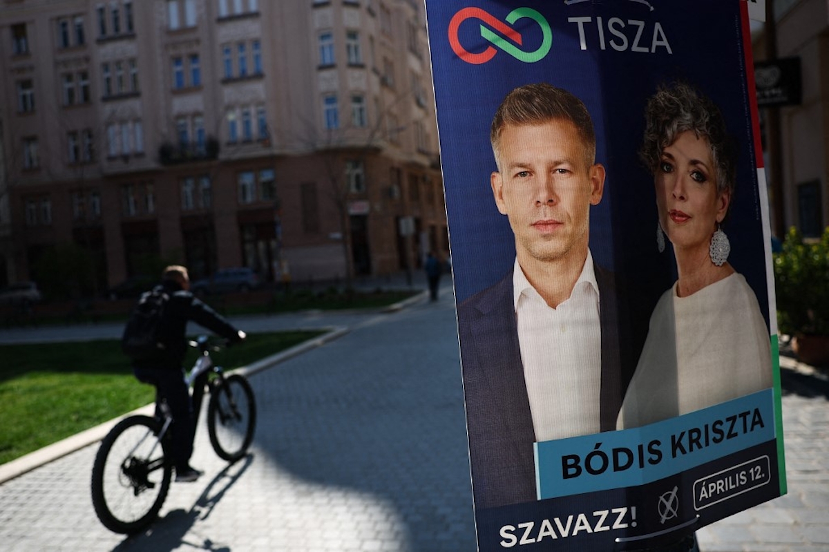 A Tisza egyik plakátja mellett biciklizik egy férfi