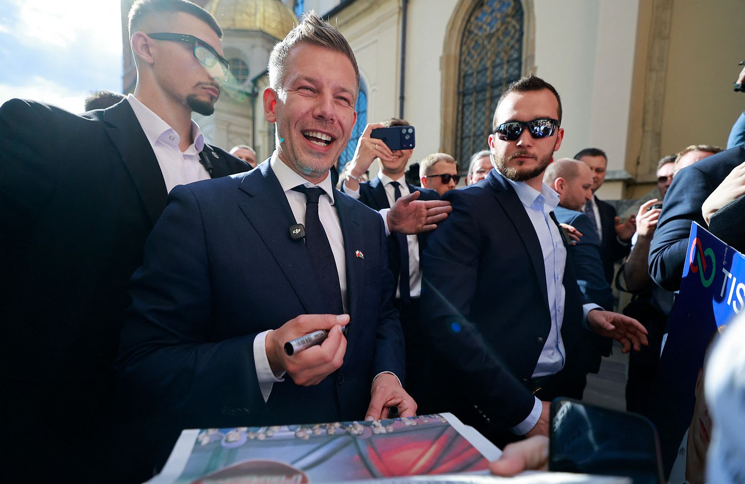 POLAND-HUNGARY-POLITICS-DIPLOMACY - Startlap A nevető Magyar Péter plakátot dedikál testőrök gyűrűjében.
