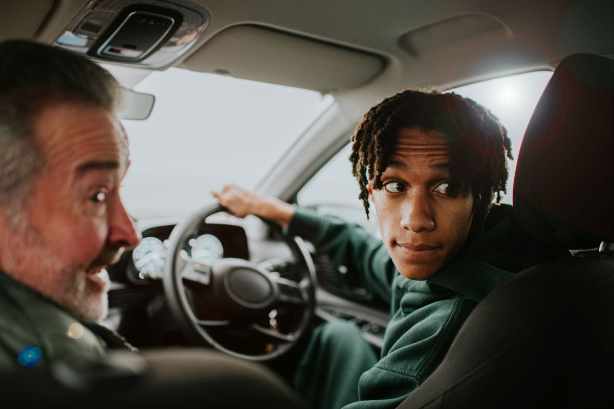 jobbkormanyos_auto_ - Startlap Egy fiatal férfi tolat az autójával, miközben hátra tekint