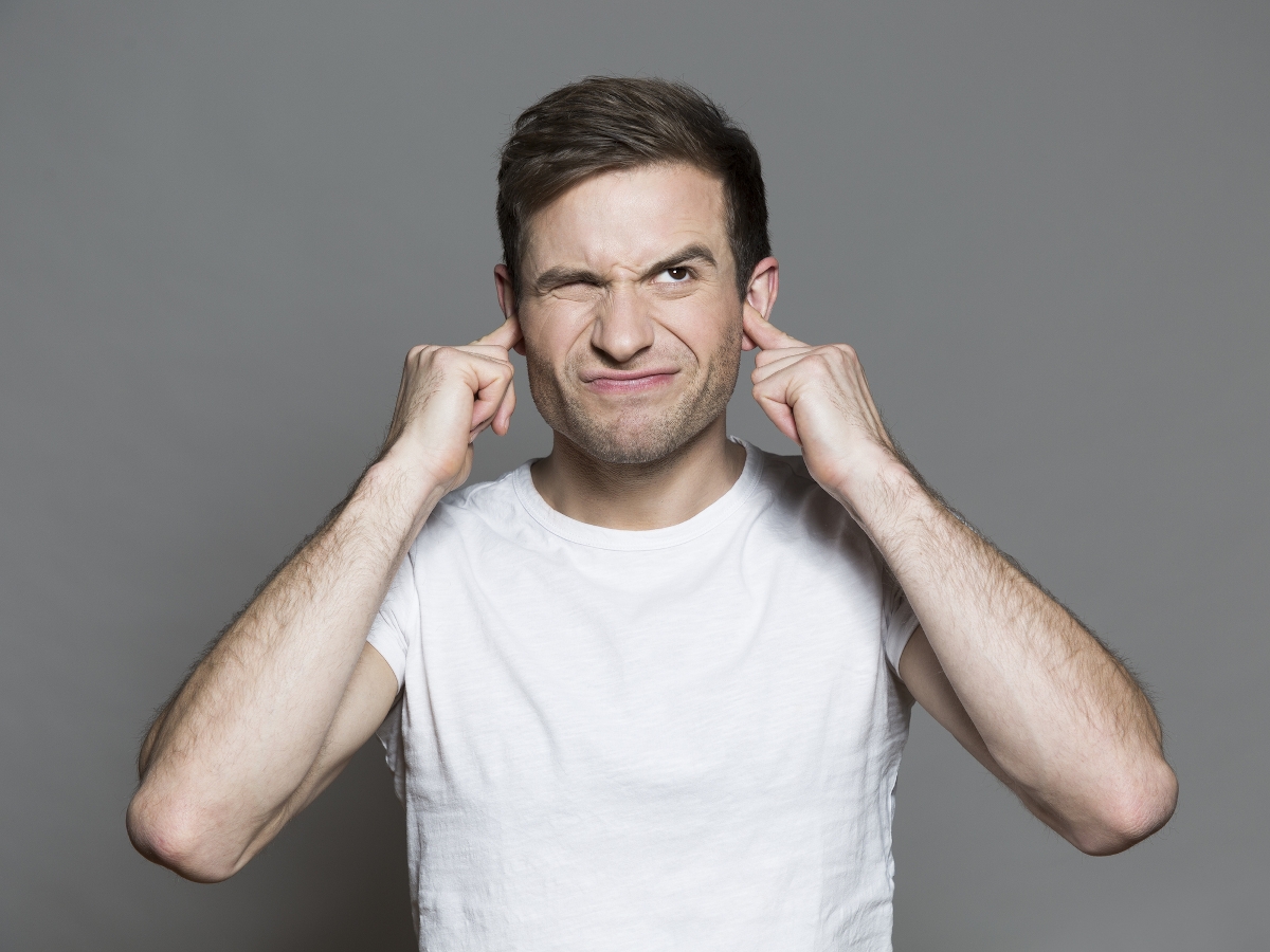 Egy férfi befogja mindkét fülét