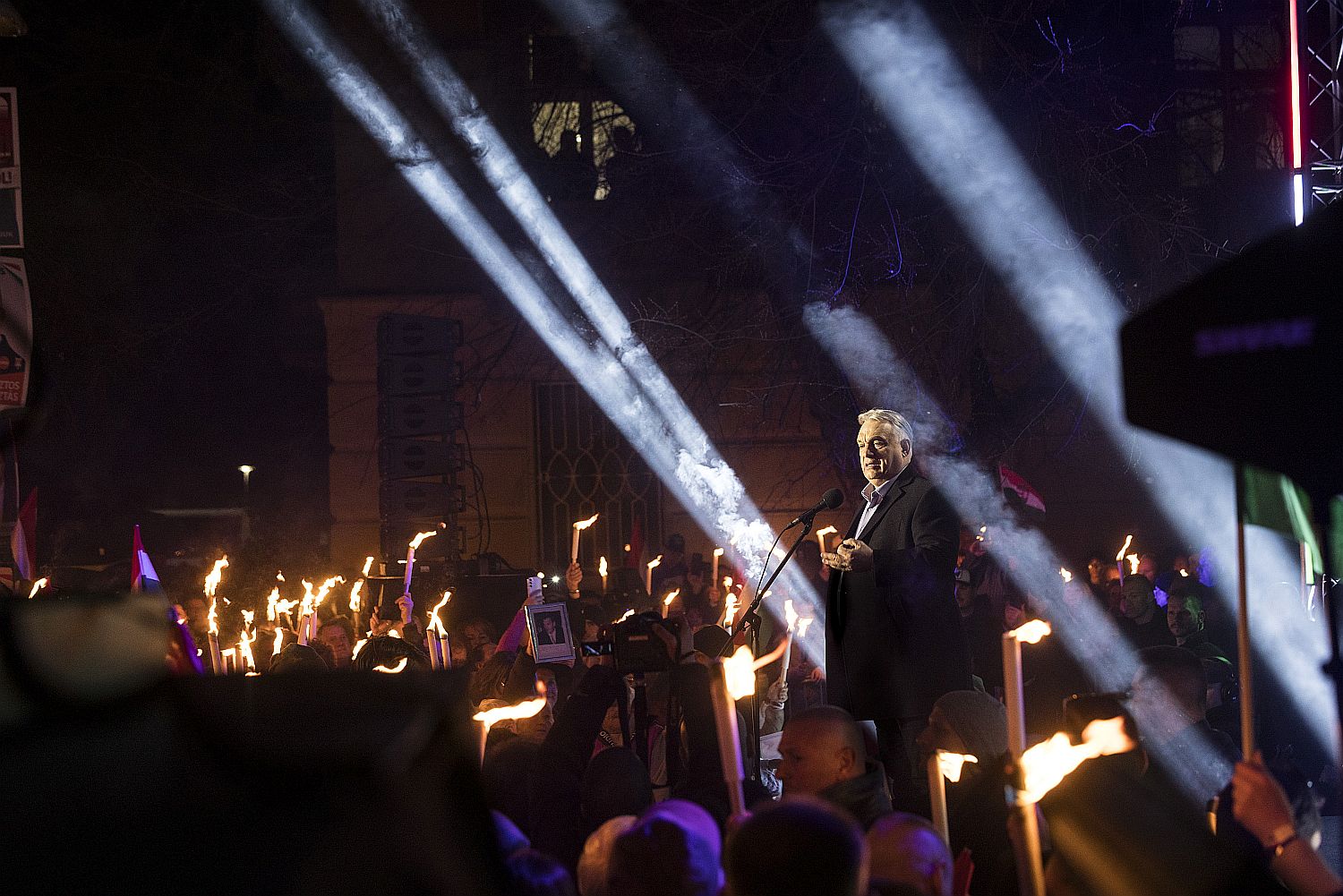 Orbán Viktor beszél fáklyákkal világító emberekhez egy téren a sötétben