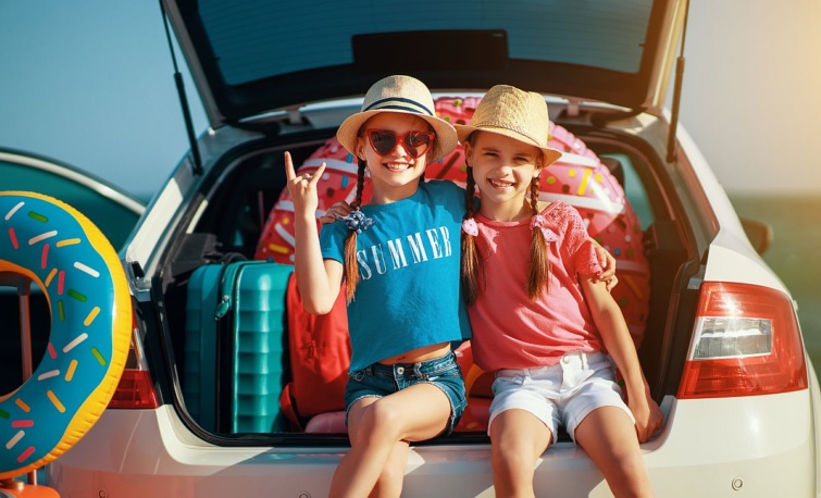 Két nyaraló gyermek egy autó csomagtartóján