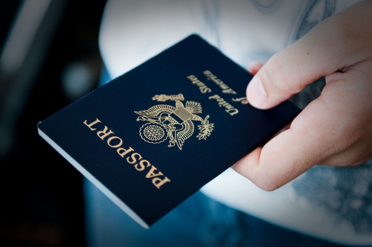 Amerikai útlevelet a kezében tartó ember.